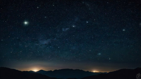 Milky way and stars in the night sky with silhouette of mountains.