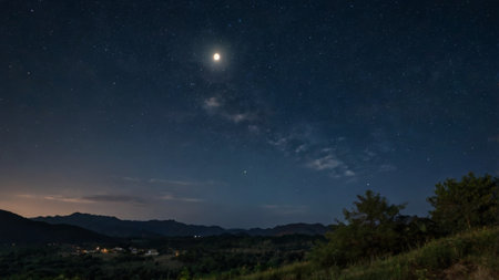 Night sky with stars and the moon over the mountains. Long exposureの写真素材