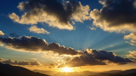 Sunset in the mountains with beautiful clouds and rays of light.の写真素材