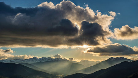 Sunset in the mountains with clouds and sunbeams.の写真素材