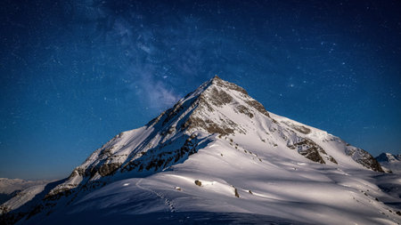 Winter mountains panorama with snow covered peaks and deep blue sky with stars