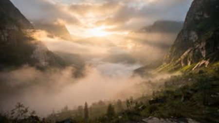 Panoramic view of the foggy valley at sunrise in the mountains