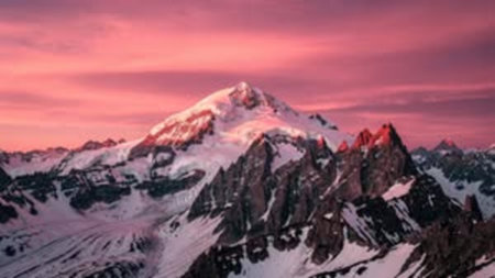 Panoramic view of snow-capped mountain peaks at sunset