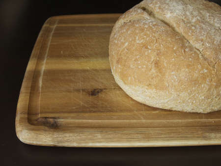 Delicious freshly baked loaf of bread  Displayed on a cutting board  の写真素材