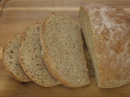 Delicious freshly baked loaf of bread  Displayed on a cutting board  の写真素材