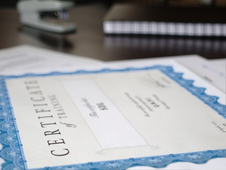 Certificate and Business Documents laid out on a dark table の写真素材
