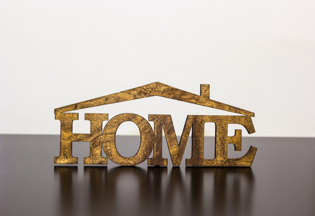 The word "home" is made of wood on a dark tableの写真素材