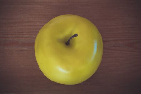 Yellow apple on a wooden backgroundの写真素材