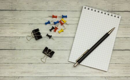 Stationery: blank notepad, pens, buttons, on a wooden gray desk. Top view. Copy space.の写真素材