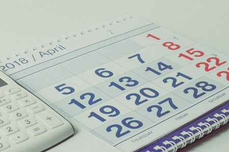 Calculator and pen on calendar backgroundの写真素材