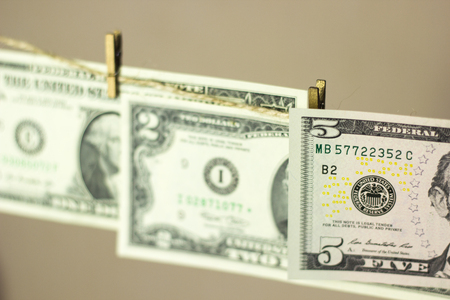 dollars are hanging on the clothesline clothespins attached