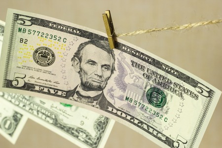 dollars are hanging on the clothesline clothespins attachedの写真素材