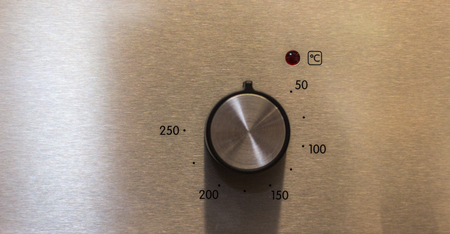 Close-up hand setting cooking mode or temperature on oven