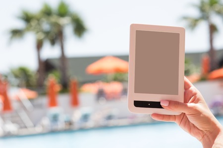 Female hand holding electronic device for reading