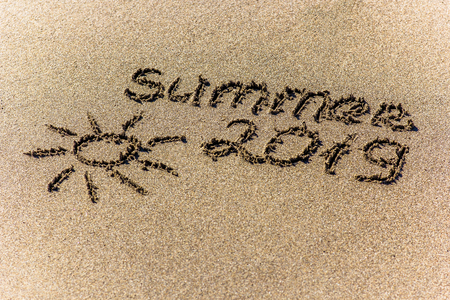 The word summer and sun written in the sand on a beachの写真素材