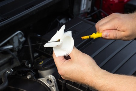 Close-up, the mechanic checks the oil level in the carの写真素材