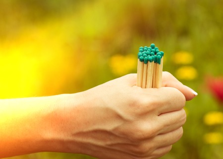 Matches in the women's hand with a light, close-up