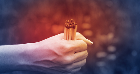Several matches in a woman's hand with a red light, the concept of fire safetyの写真素材
