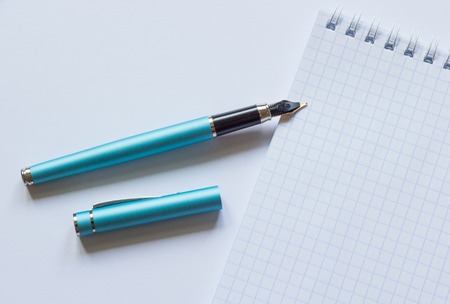 Fountain pen and notebook on a white backgroundの写真素材