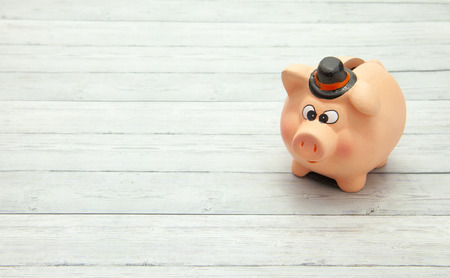 Ceramic pink piggy bank on wooden background, space for textの写真素材