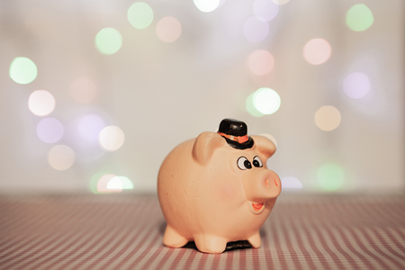 Ceramic piggy bank on a blurred background, concept of saving moneyの写真素材