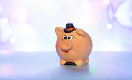 Ceramic piggy bank on a blue blurred background, concept of saving moneyの写真素材