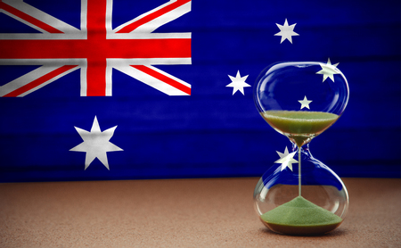 Hourglass on the background of the Australia flag, the concept of time and countries, space for textの写真素材