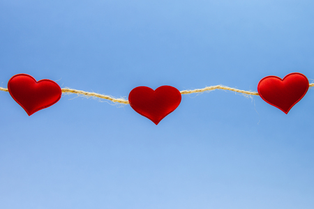 Red hearts on light blue background, strong love conceptの写真素材
