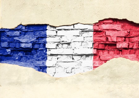 National flag of France on a brick background. Brick wall with partially destroyed plaster, background or texture.の写真素材