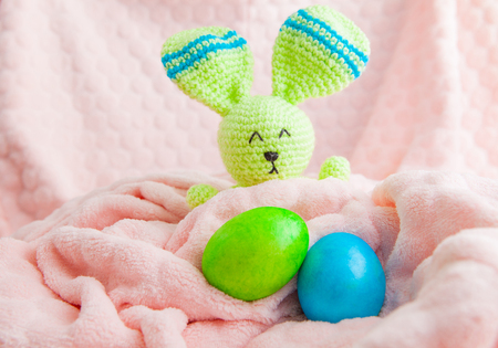 Beautiful colorful easter eggs and bunny toy. Easter concept on a soft plaidの写真素材