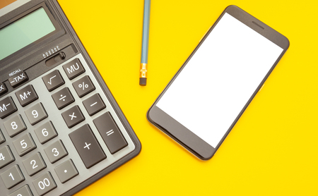 Modern calculator and phone with space for text on a yellow background, top viewの写真素材