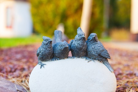 Garden decor, birds on white stone on a blurred backgroundの写真素材