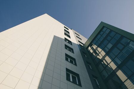 Modern apartment building with glass against a blue sky