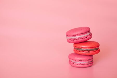 Red and pink macaroons on coral background, home-made foodの写真素材