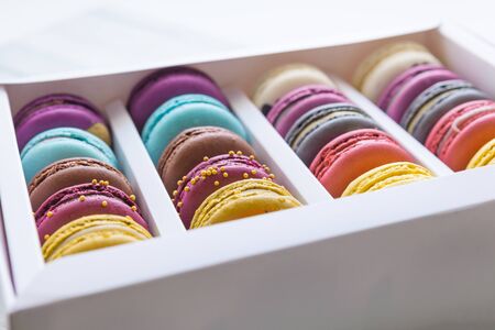 Set of different french cookies macaroons macaroons in a paper box. Top view. Any tastes. Coffee, chocolate, vanilla, lemon, rapsberry, strawberry, pistachio, violet, rose, orange tastes macaroonsの写真素材