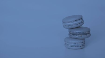 Red and pink macaroons on coral background, home-made food, toned trendy classic blue color of year 2020の写真素材