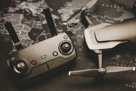 Drone copter with remote controller on world map background, close-up