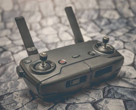 Modern remote control drone or copter on the background of stones