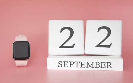 Modern Watch with cube calendar and date 22 september on pink background. Concept autumn time vacation.の写真素材