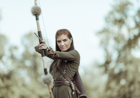 Young girl archery aiming at target, atmospheric photography