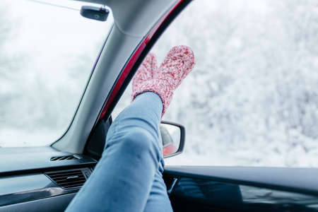 Young woman in warm socks resting inside car, close-up.の写真素材