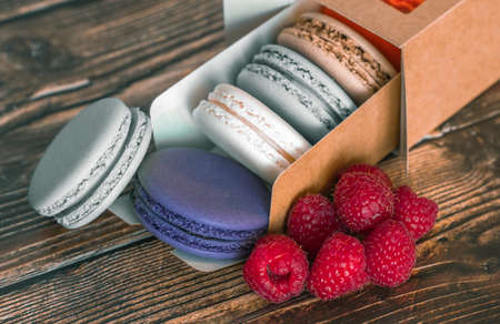 Cardboard box with macaroon cookies and raspberries, a favorite treat for children