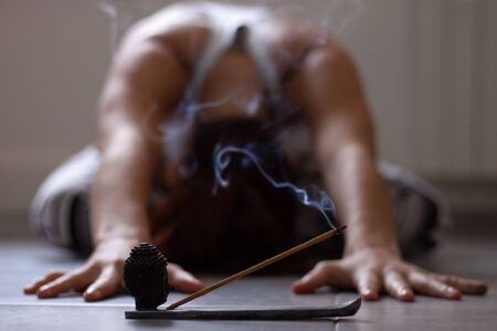 Close up to woman doing childs pose in yoga class at homeの写真素材