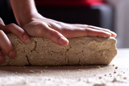 Working hands kneading bread gluten free doughの写真素材