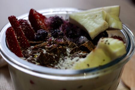 Healthy smoothie bowl with granola, fresh strawberries, blueberries, coconut, chocolate, yogurt and chia seeds. Healthy food, snack or breakfast.の写真素材