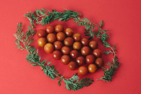 Fresh red cherry tomatoes on red backgroundの写真素材