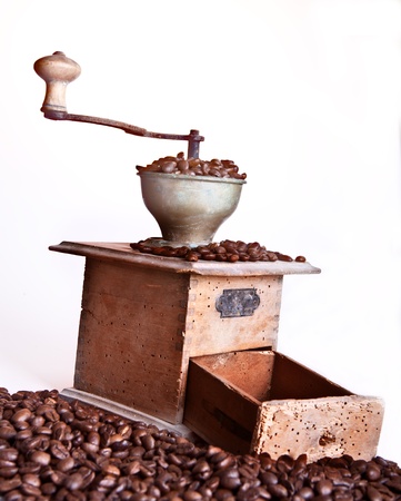 Coffee grinder with coffee beans over white backgroundの写真素材
