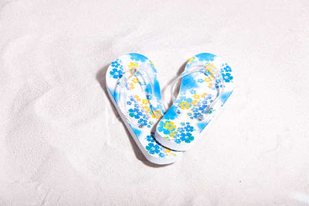 Flip flops on the beach on sandの写真素材