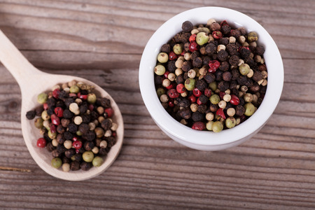 Pepper mixture on spoon over wooden backgroundの写真素材