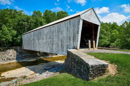 White covered bridge with blue sky.